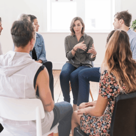 A group of people sit in a circle, engaged in a discussion. Christians and AA