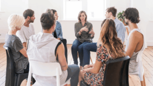 A group of people sit in a circle, engaged in a discussion. Christians and AA