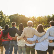 Group of multigenerational people hugging each others - Support, multiracial and diversity concept - Main focus on senior man with white hairs