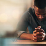 Black man, hands and praying with worship and banner,  God and religion, faith with guidance and gratitude. Respect, spiritual and prayer with belief, blessing and mockup space with bokeh and trust