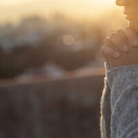 Women raise their hands to ask for blessing from God.